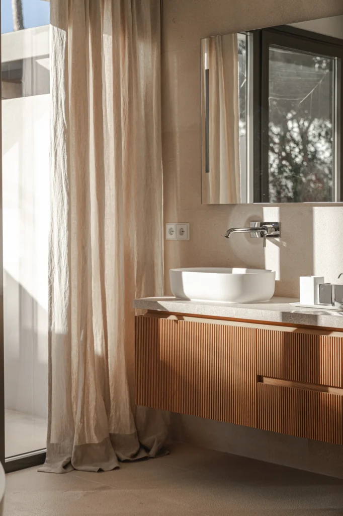 Lavabo con espejo y vistas al jardín en el proyecto Pinar de Sa Dutxeta