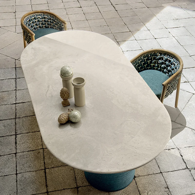 Mesa ovalada de exterior con sillas de cuerda trenzada de la colección Patio de Ethimo