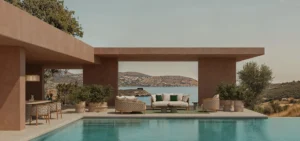 Salón exterior junto a la piscina con sofás de fibra trenzada de la colección Patio de Ethimo