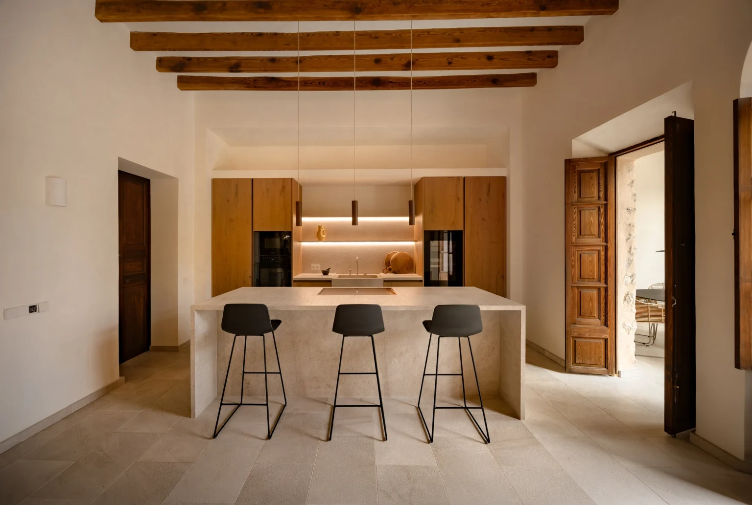 Cocina con puerta antigua de madera al fondo en el proyecto 1906 de Sa Dutxeta en Soller, Mallorca