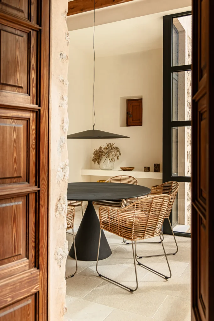 Comedor con mesa redonda y sillas de ratan en el proyecto 1906 de Sa Dutxeta en Soller, Mallorca